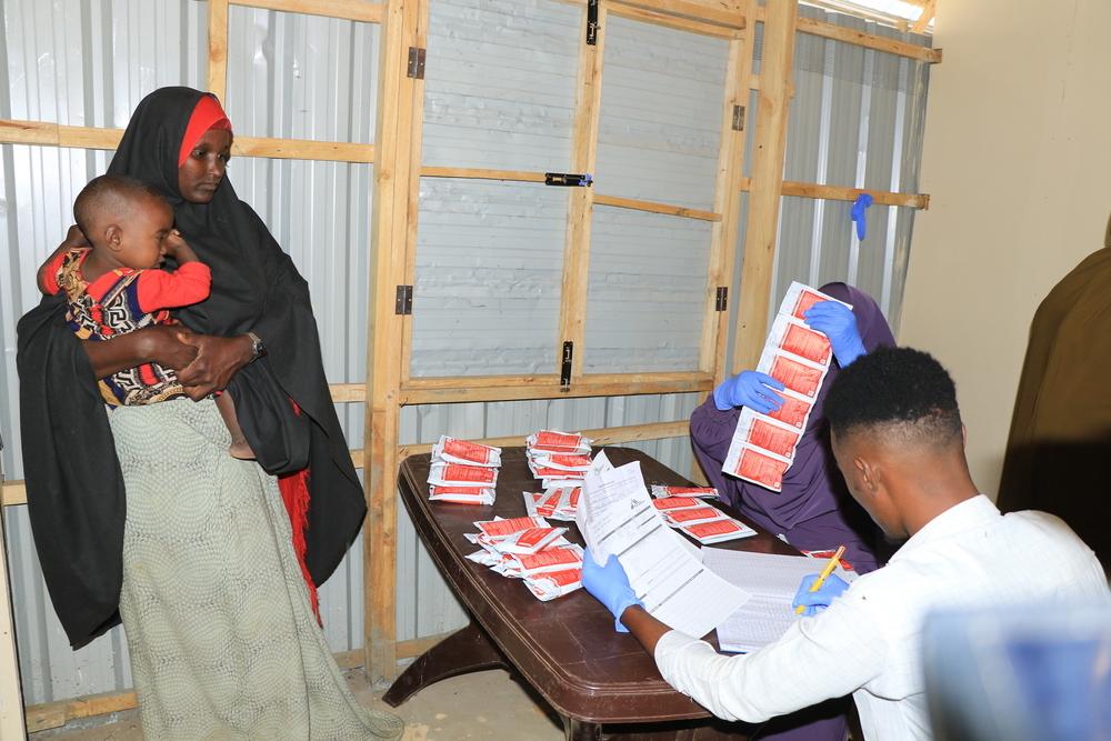 Personnel MSF expliquant à une mère comment donner à son bébé un supplément nutritif prêt à l'emploi, dans le centre de proximité décentralisé géré par MSF près du camp d'Elbet-I, à Baidoa, en Somalie. Juin, 2024 © Bishar Mayow/MSF