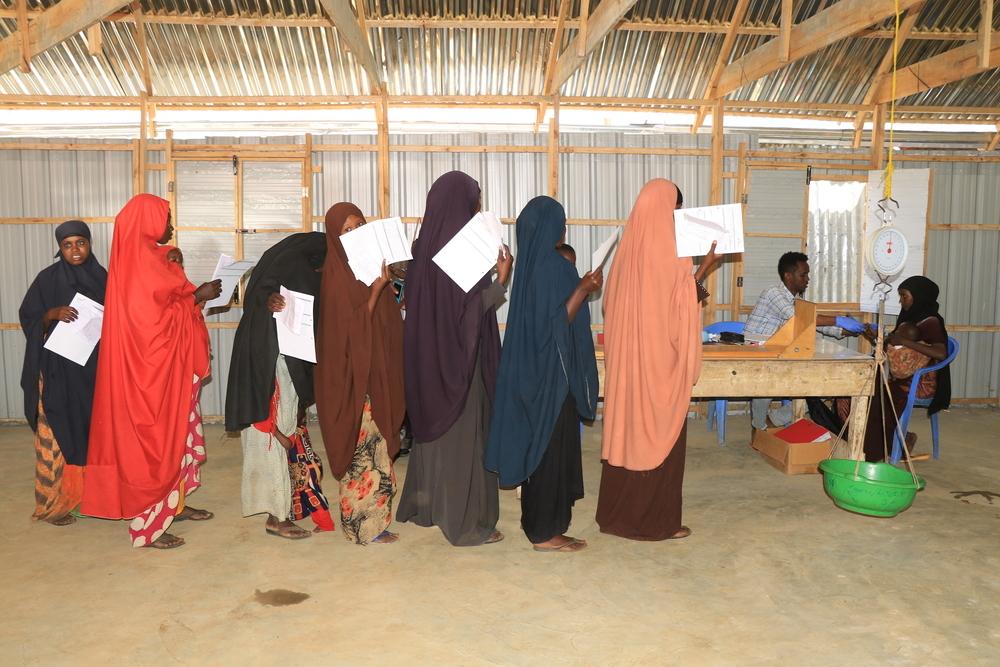 Un groupe de mères faisant la queue pour mesurer la taille et le poids de leurs enfants, afin de recevoir des compléments nutritionnels prêts à l'emploi dans le centre de proximité décentralisé soutenu par MSF près du camp de déplacés d'Eelbet-I, à Baidoa. Juin, 2024 © Bishar Mayow/MSF