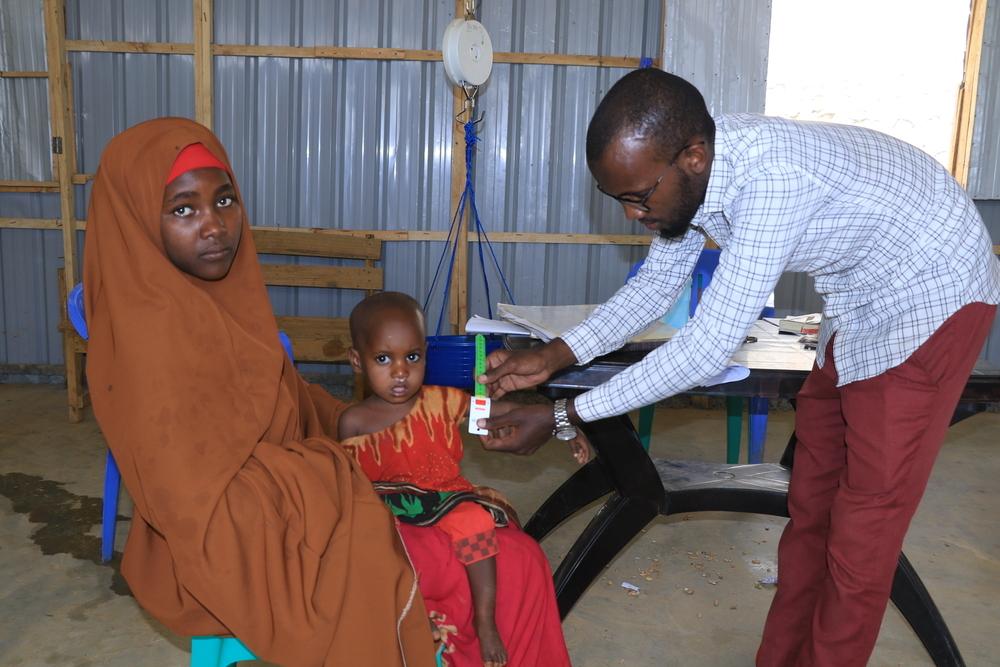 Une infirmière MSF mesure la circonférence moyenne du haut du bras (MUAC) d'un enfant de 18 mois au centre de proximité décentralisé soutenu par MSF près du camp de déplacés d'Afmadow à Baidoa. Juin, 2024 © Bishar Mayow/MSF