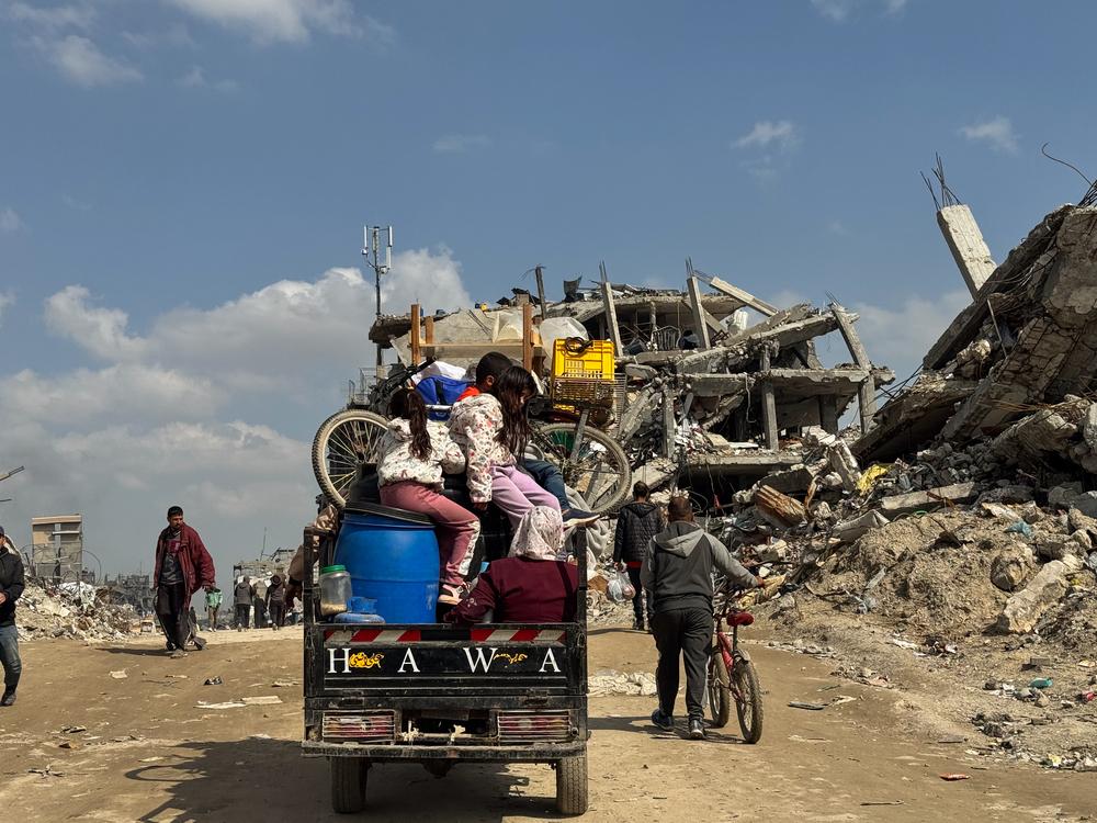 Une famille palestinienne déplacée voyageant en tuktuk et revenant s'installer dans la ville de Beit Lahia, au nord de la bande de Gaza.