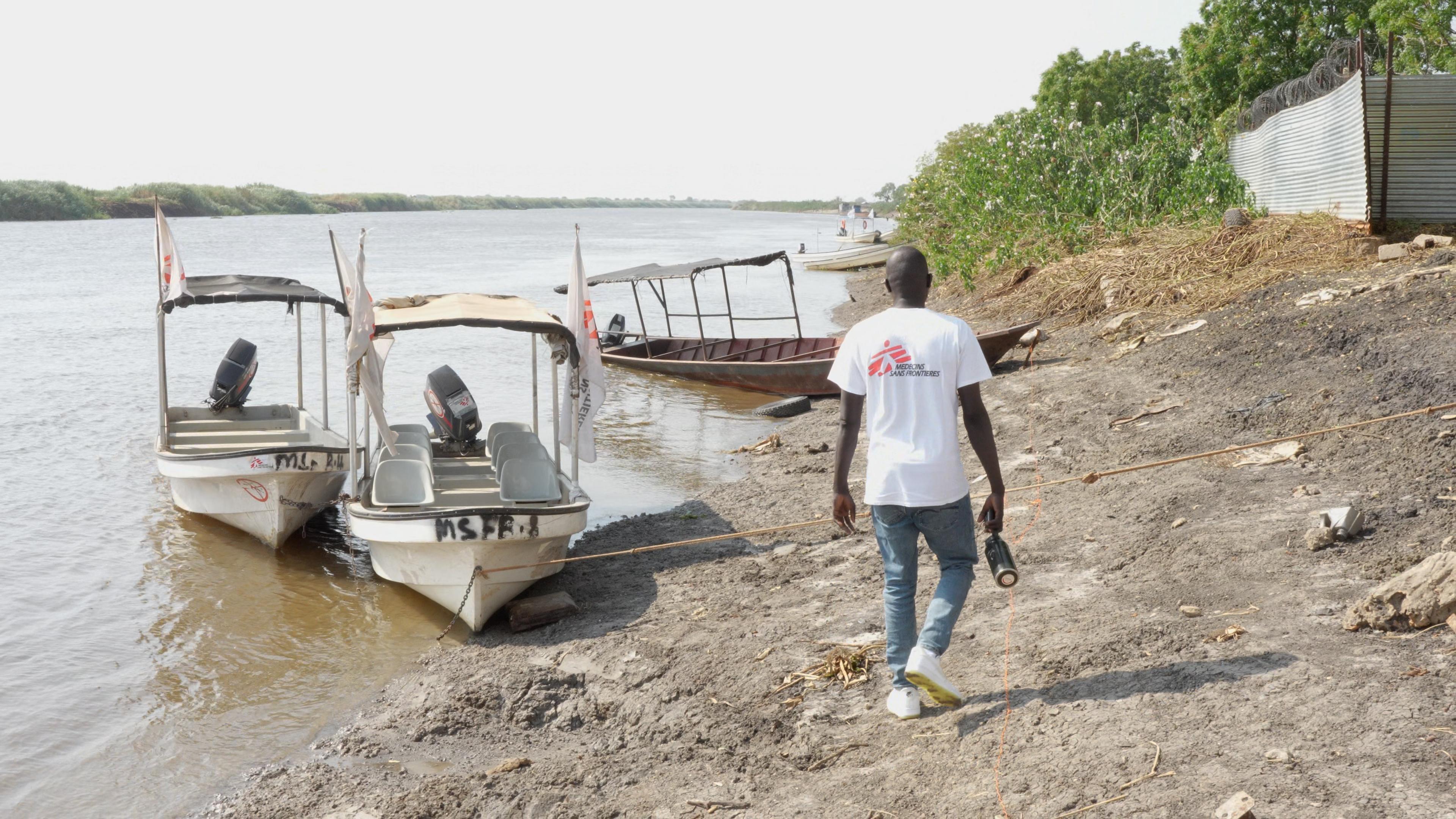 Un membre du personnel de MSF marchant vers les bateaux de MSF à Ulang.