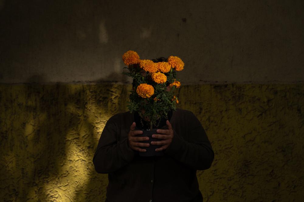 Une Vénézuélienne, qui raconte avoir été violée par un groupe d'hommes après avoir traversé le Darien, se couvre le visage de fleurs de souci (Cempasúchil) au Centre de soins complets (CAI) géré par MSF à Mexico. 