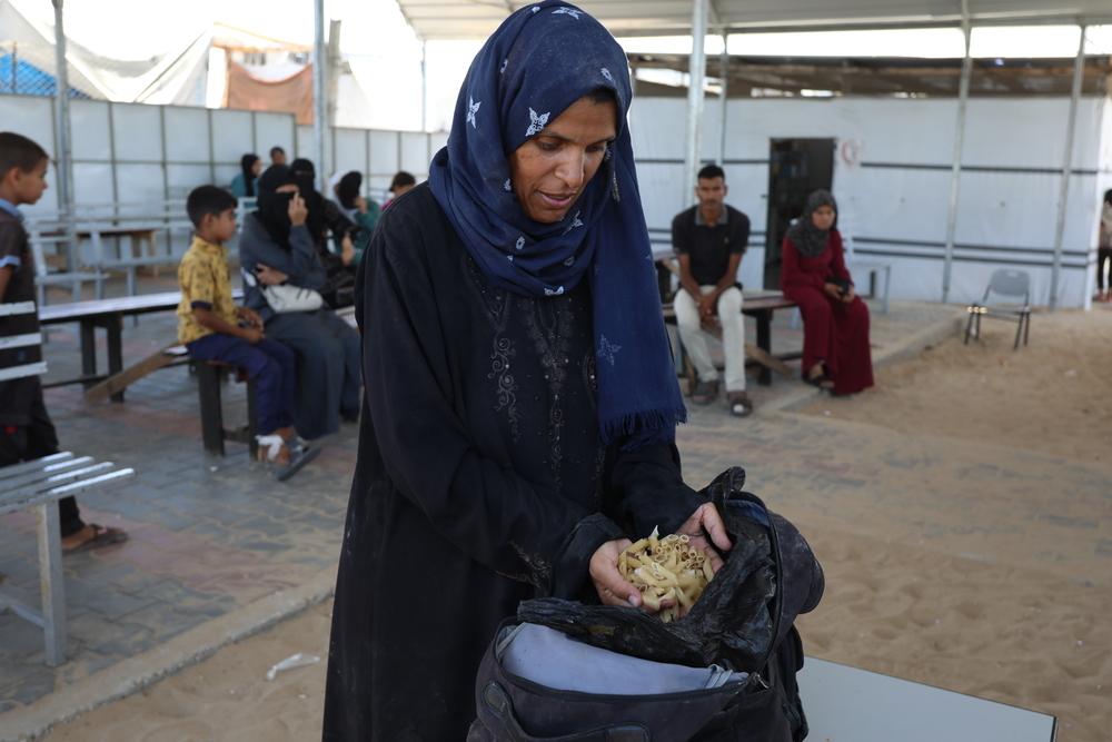 Samah Hamdan, mère déplacée et soignée au centre de soins primaires de Mawasi, à Rafah, montre les pâtes qu’elle a ramassées par terre sur un site de distribution de l’aide américano-israélienne pour nourrir ses enfants . Après avoir marché plus de 15 km pour acceder cette zone rouge, elle n’a rien pu obtenir d’autre. Juin, 2025 © MSF