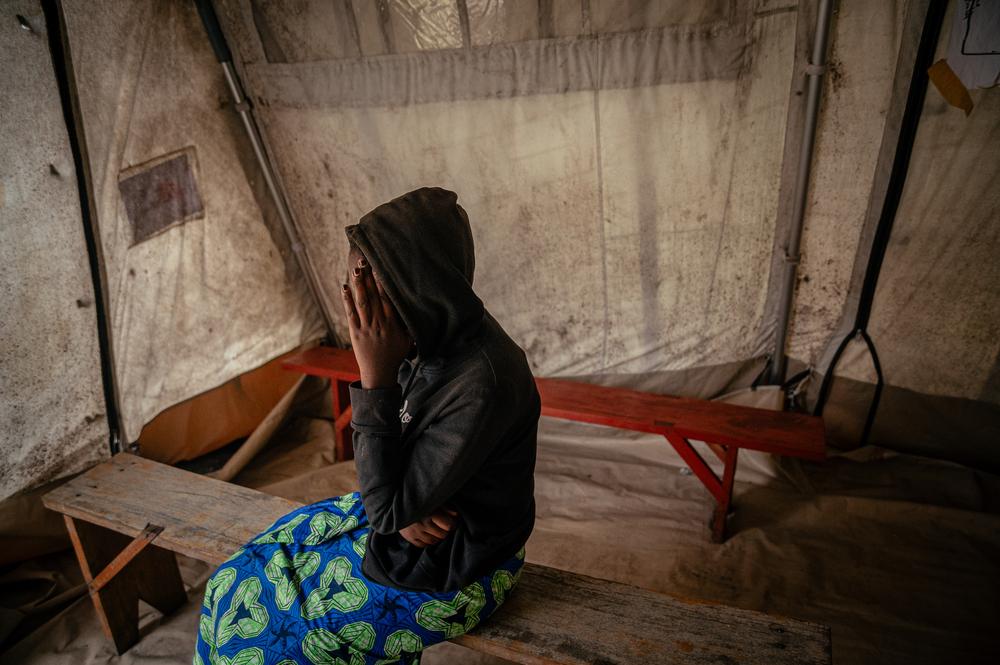 Joëlle (prénom modifié). Portrait d'une mineure de 17 ans dans une tente au centre de santé de CCLK à Goma. Orpheline, elle vit seule avec ses trois petits frères depuis la mort de leurs parents. Après un entretien avec le superviseur MSF en charge de la protection, elle est venue recevoir des soins dans le cadre de sa prise en charge. 