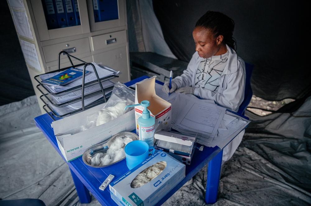 Une infirmière de MSF rédige son rapport en attendant les patientes, survivantes de violences sexuelles, qui viendront la consulter après être passées par la tente de triage du centre de santé de Mugunga 3 à Goma. 