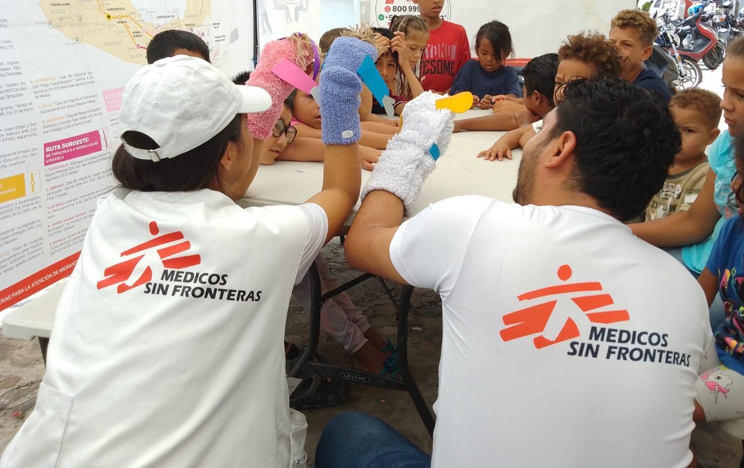 Deux membres de l’équipe de promotion de la santé dirigent une activité éducative auprès d’enfants migrants.