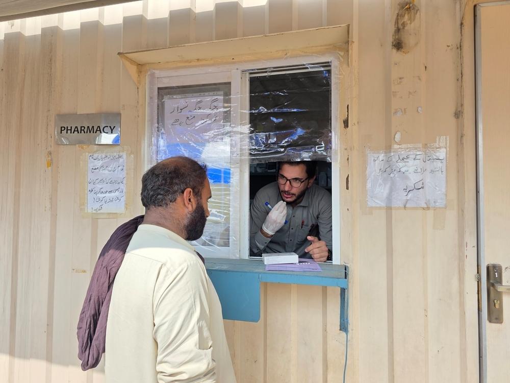 Un pharmacien de MSF explique l'ordonnance à un patient au guichet de la pharmacie après son examen à la clinique MSF dans la vallée de Tirah