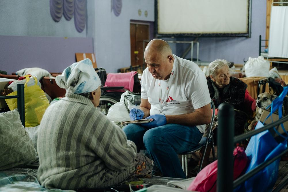 Un membre du personnel de MSF aux côtés d'une patiente en Ukraine 