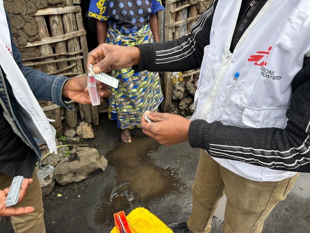 Deux techniciens de l’eau, de l’hygiène et de l’assainissement de MSF testent la qualité de l’eau à un point de chloration mis en place par MSF à Goma, en République démocratique du Congo, en mars 2025. Ils mesurent le taux de chlore afin de vérifier si l’eau est potable. © Abdon MANENGU Mbangala/MSF