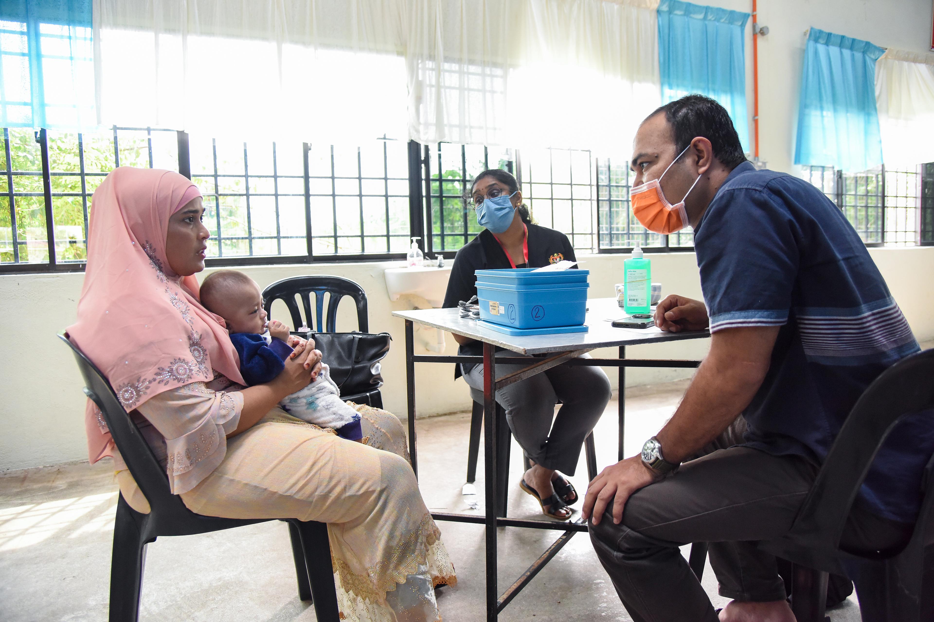 Une femme rohingya parle à un interprète bénévole