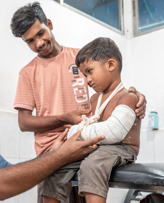 Camp de réfugiés de Kutupalong, réponse des Rohingyas : Azis Mohammad est arrivé à la clinique MSF de Kutupalong avec son neveu Raihan, âgé de cinq ans, après que le garçon soit tombé d’une table et se soit cassé le bras.
