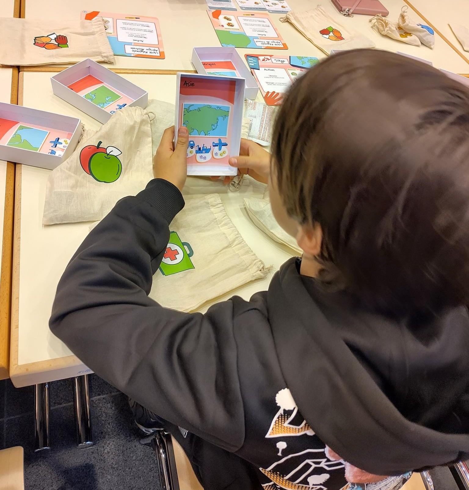 Un jeune garçon tient la boîte de jeu de TimeRush lors d'une partie jouée à GameOn, les 15-16 novembre 2025