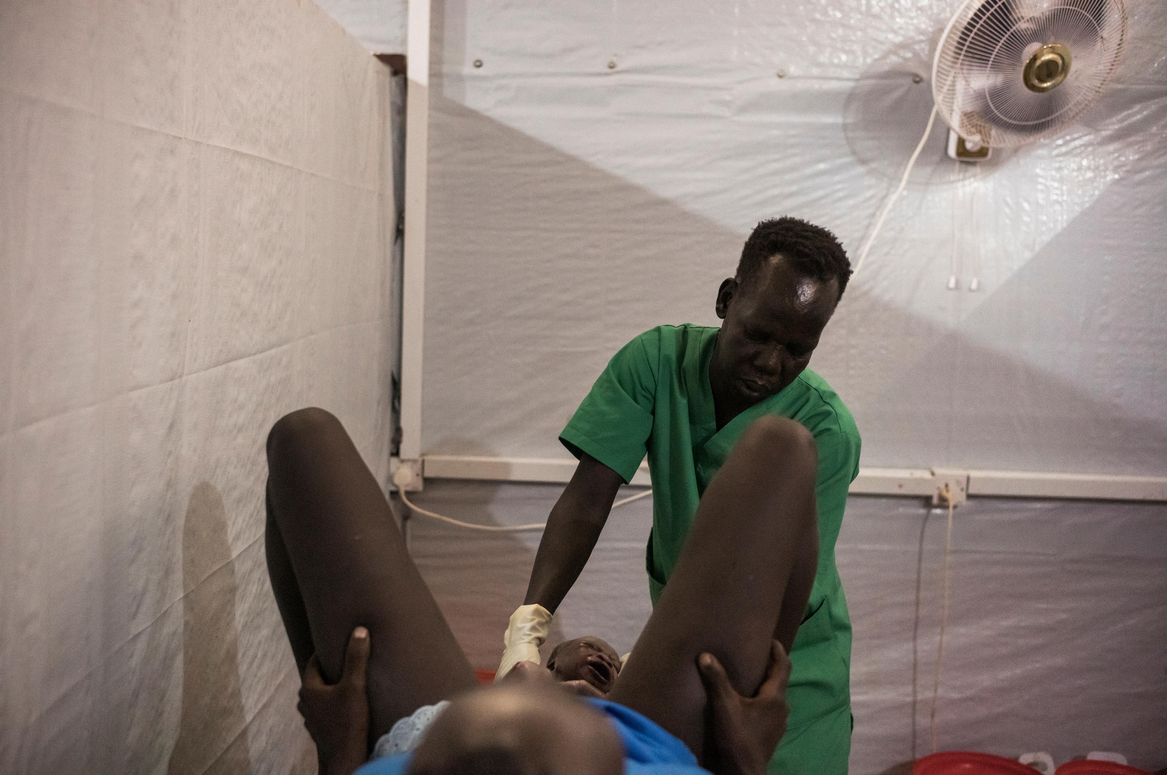 Abuk Magolc Dhal accouche dans l'hôpital géré par MSF avec le soutien de sa mère, Nyadeng Mangolc, Mayen-Abun, Soudan du Sud. 