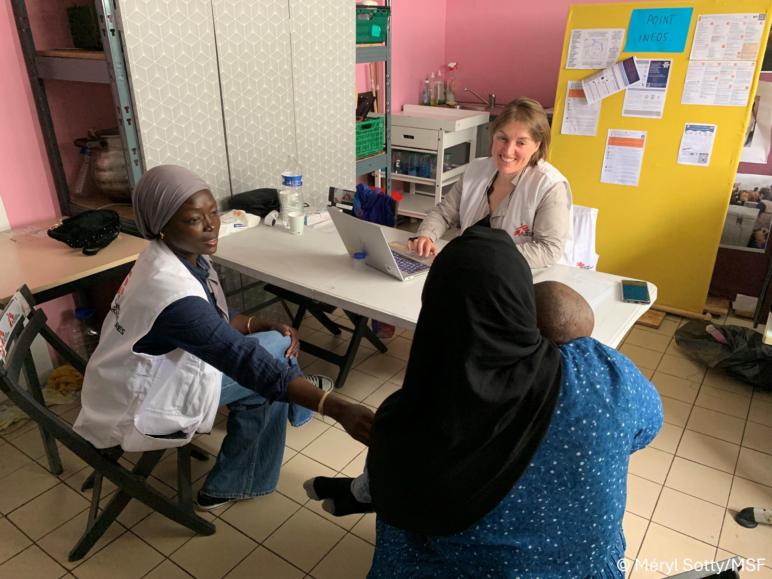 Elise Houard, infirmière MSF, et Amira Babakar, médiatrice interculturelle MSF, en consultation médicale avec une femme exilée et son enfant, au centre d’accueil de jour du Secours Catholique à Calais 