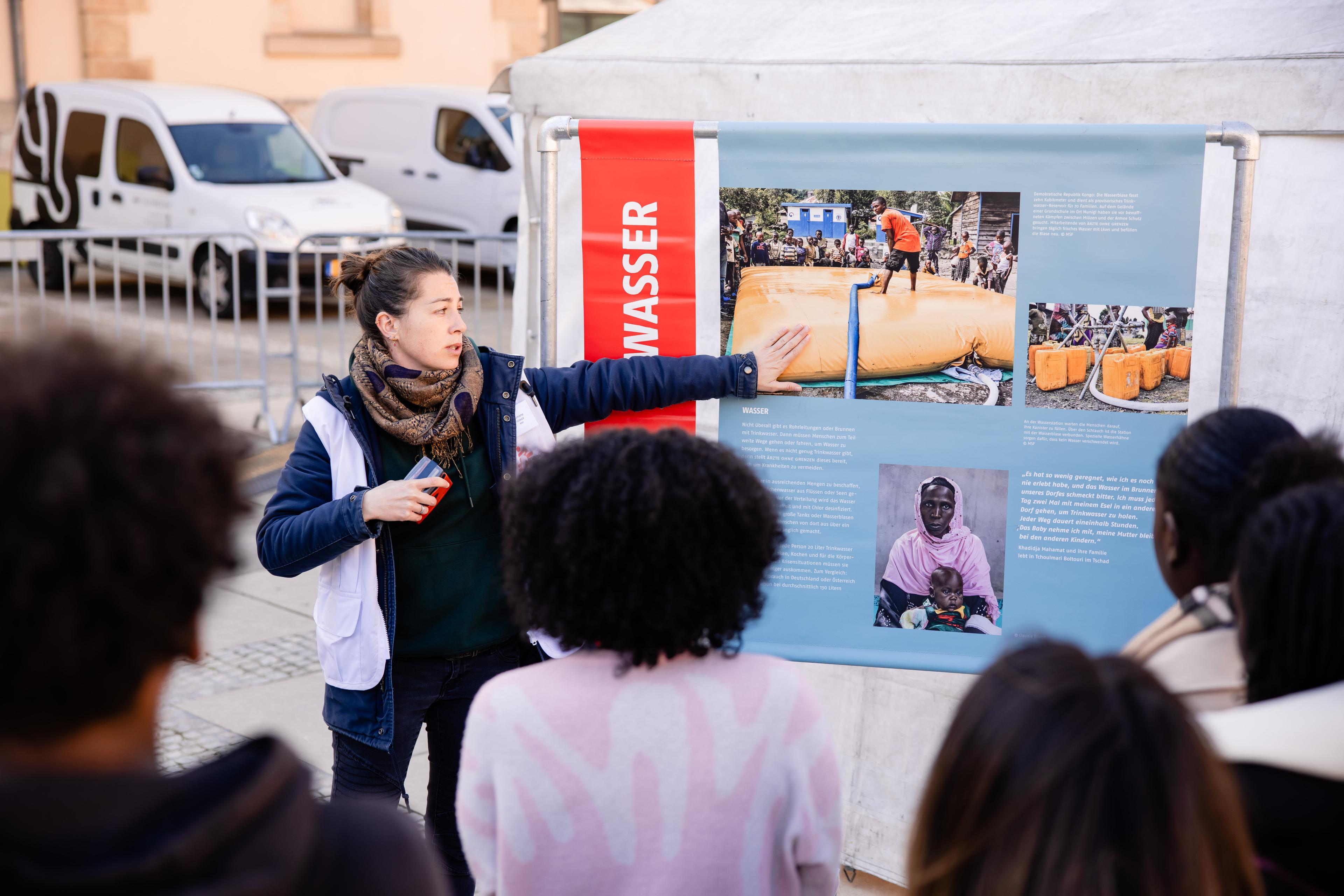 Romane, logisticiènne et employée international mobile pour MSF, fait découvrir « La Grande Expo » à un groupe d'étudiants. Luxembourg. Mars, 2026 © Nelson Coehlo/ MSF