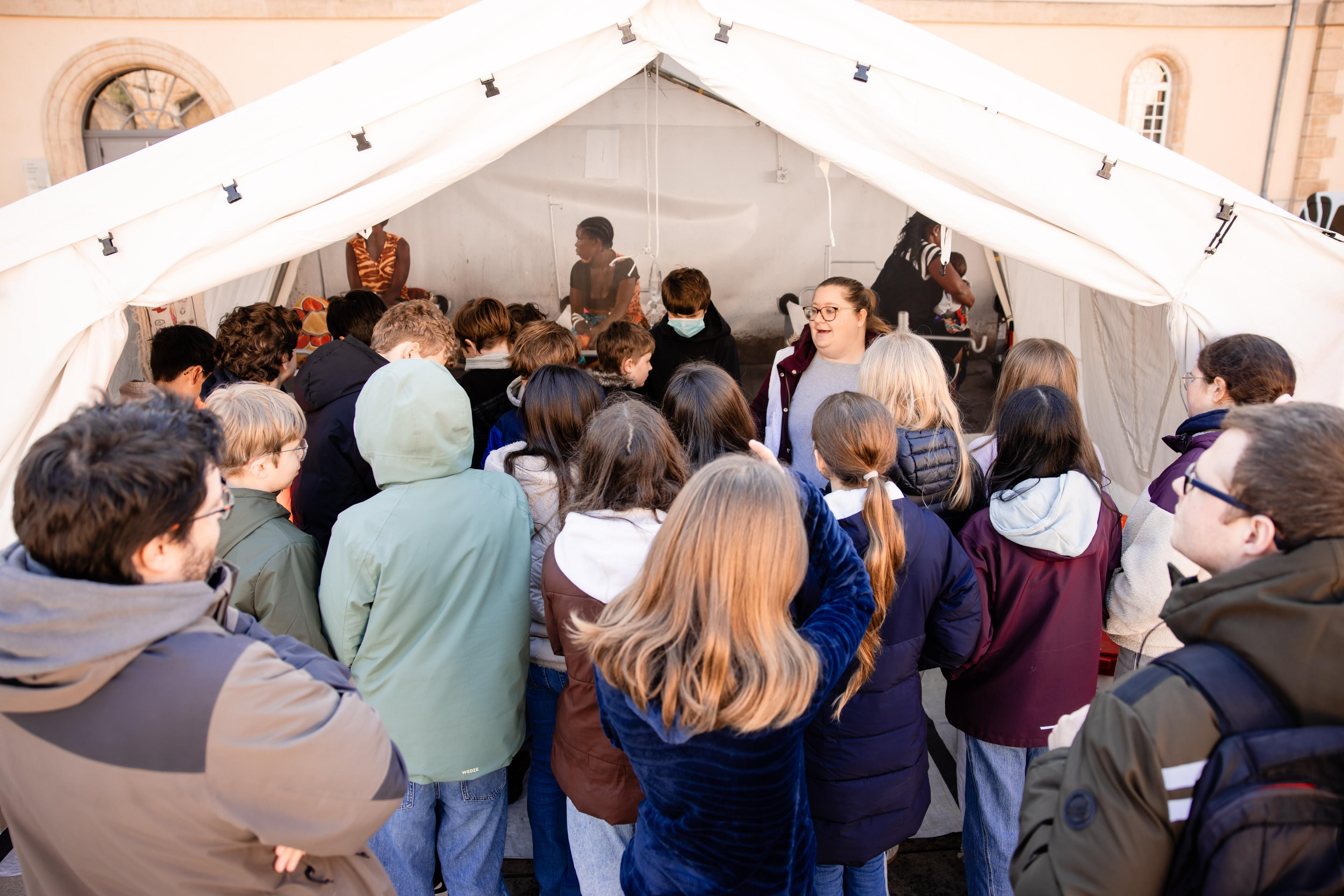 Sarah, ingénieure experte en eau et assainissement, ainsi qu'employée international mobile pour MSF, fait découvrir « La Grande Expo » à un groupe d'étudiants. Luxembourg. Mars, 2026 © Nelson Coehlo/ MSF