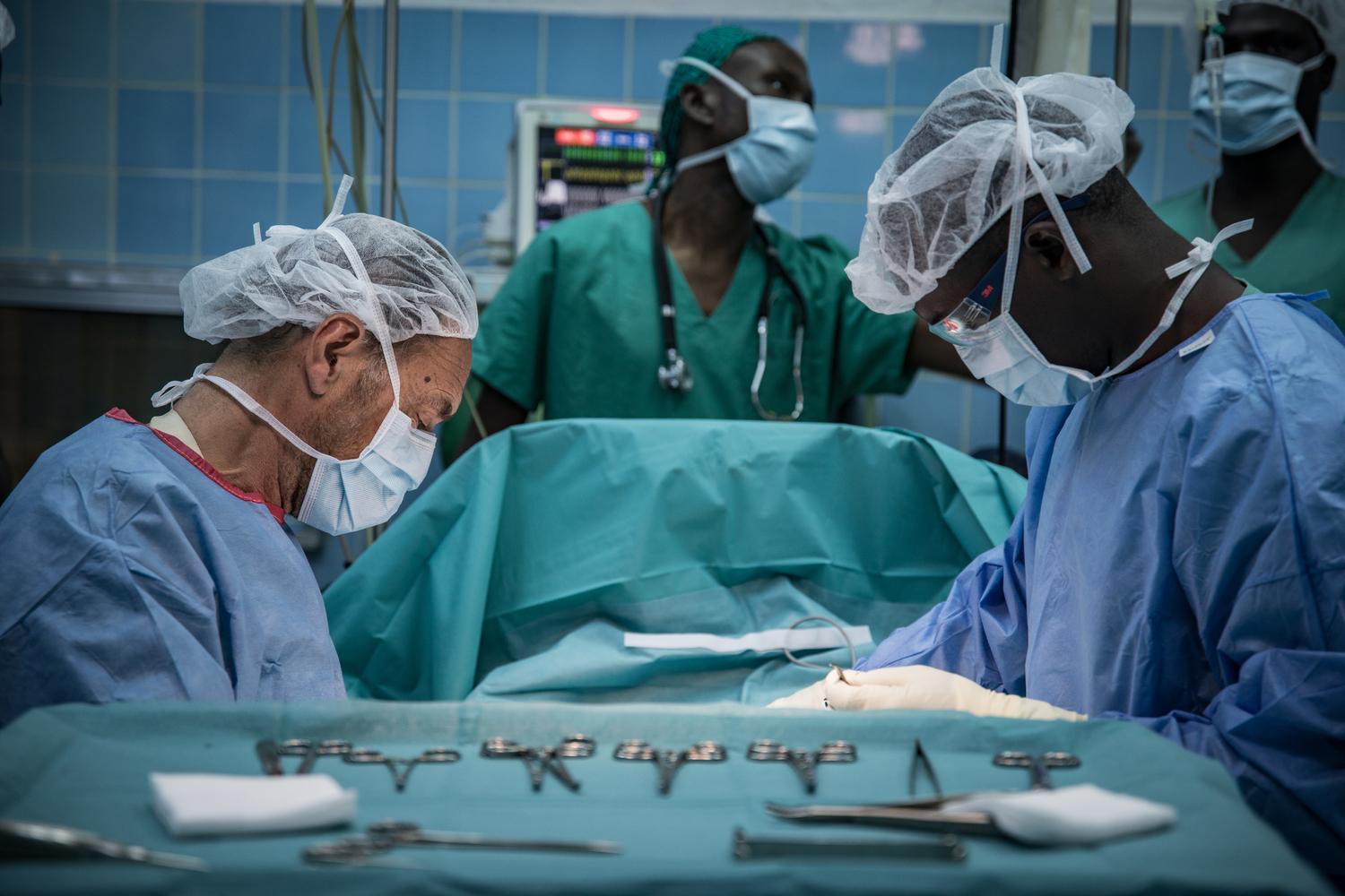 Un chirurgien et un infirmier travaillant pour MSF, pendant l&#039;opération d&#039;un enfant atteint d&#039;une forme sévère de paludisme, à l’hôpital régional de Maroua. Région de l&#039;Extrême Nord au Cameroun. Février 2019. 
