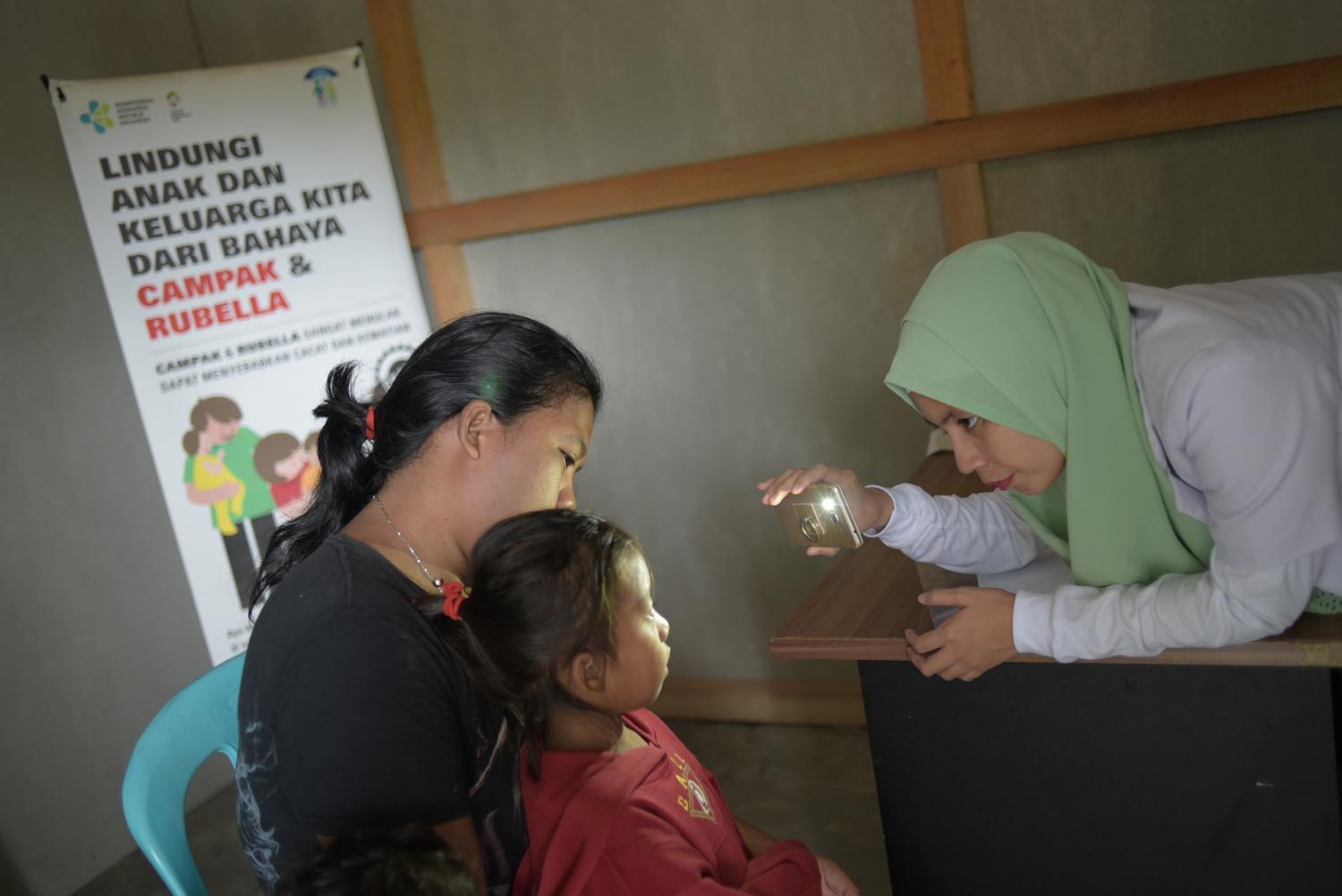 Une docteure examine une jeune patiente dans le centre de santé provisoire que MSF a construit après la triple catastrophe qui a frappé le centre de Sulawesi. Indonésie. Mars 2019. 