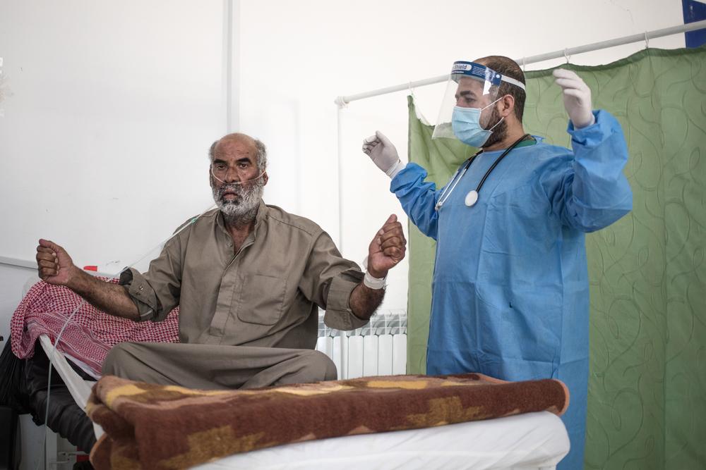 Abdul Harma, head nurse at the hospital specialising in COVID-19 in Hassakeh, in northeast Syria, treats Mr. Ali with breathing exercises. 