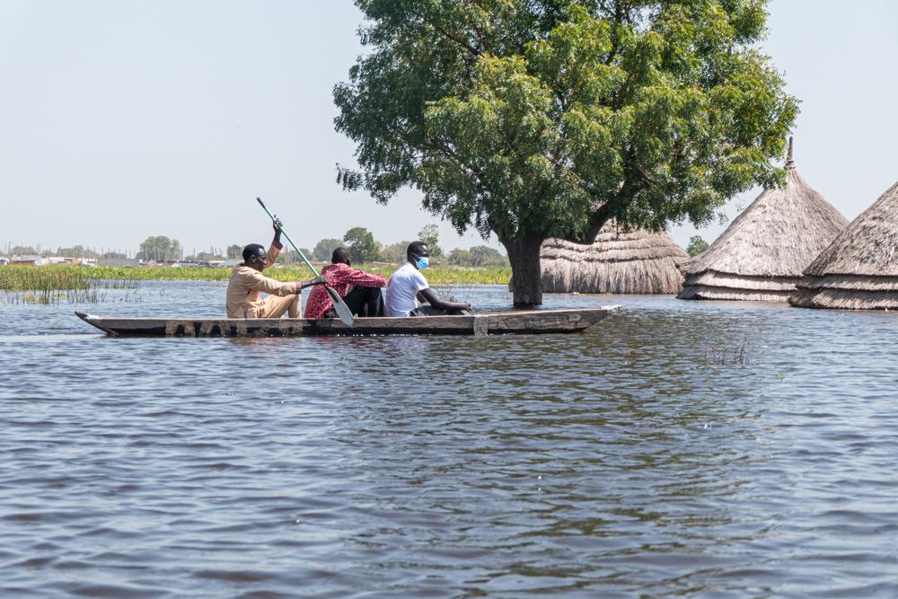 Men in a canoe navigate flood waters in Bentiu. 