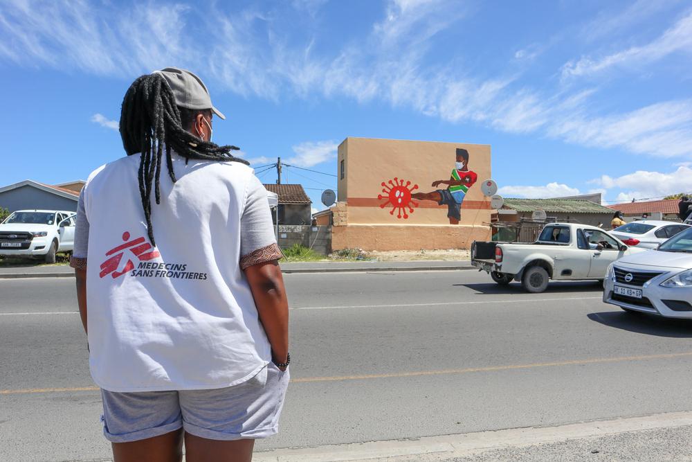 Phumeza, membre de l&#039;équipe MSF, se tient au-dessus de la route et regarde la peinture murale. 