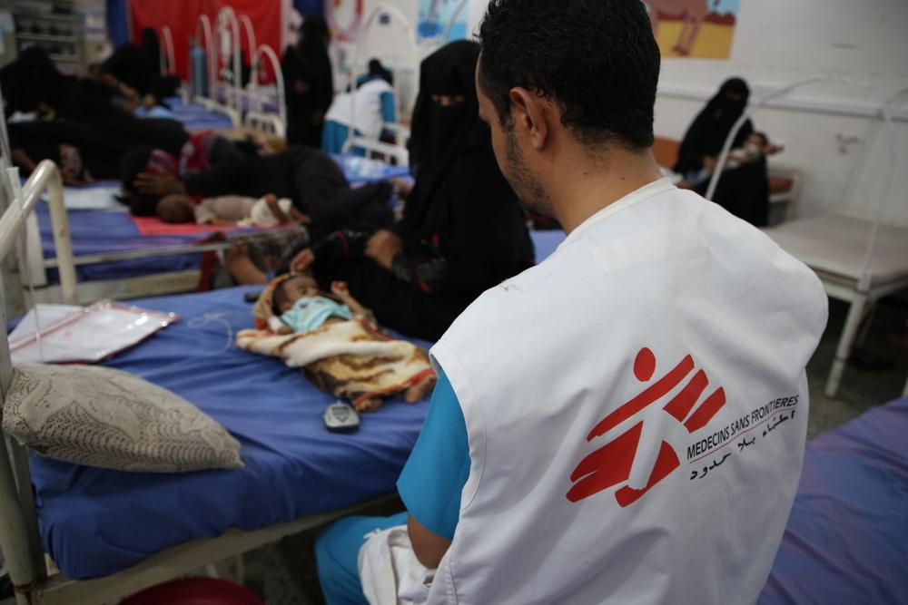 Un membre du personnel médical de MSF parle à la grand-mère d'Ali Ahmed Hajouri, un bébé de 3 mois, qui est soigné pour malnutrition au centre soutenu par MSF à l'hôpital Abs de Hajjah, au Yémen. 