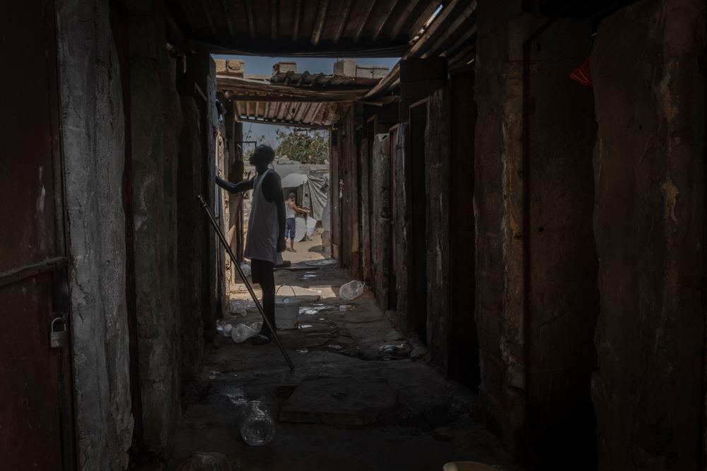 A man standing in between shared dwellings in Saraj, Libya, where a group of migrants and refugees live together. August 2021.  