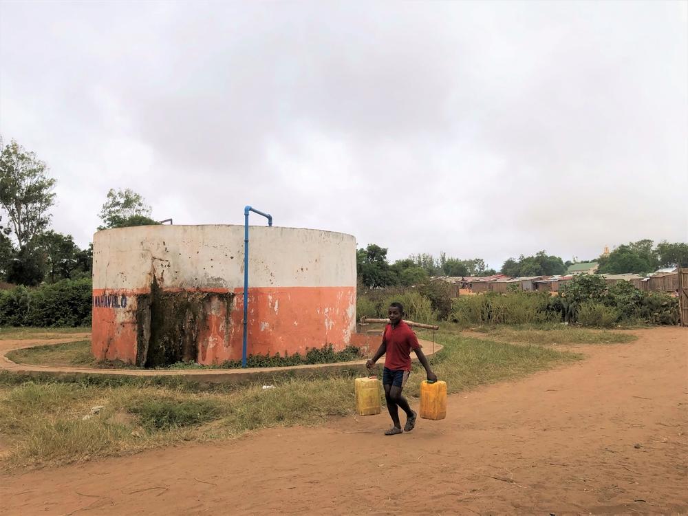 A young boy carries two cans of water in the city of Ambovombe. 