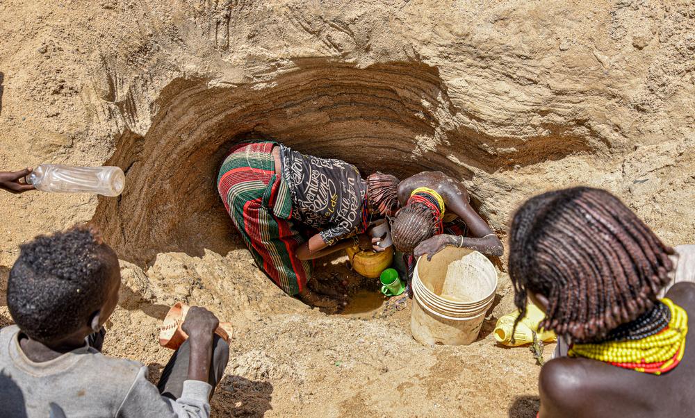 Women fetch water in one of the shallow wells along a dry river bed in Illeret. The ravaging drought has led to a water shortage in the region forcing residents to look for alternative water sources, unsafe for human consumption. 