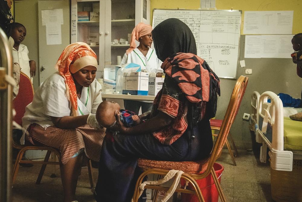 Ministry of Health staff at the hospital measuring the mid-upper arm circumference of a child during a malnutrition screening at the inpatient therapeutic feeding centre in Dupti hospital, Afar region. 