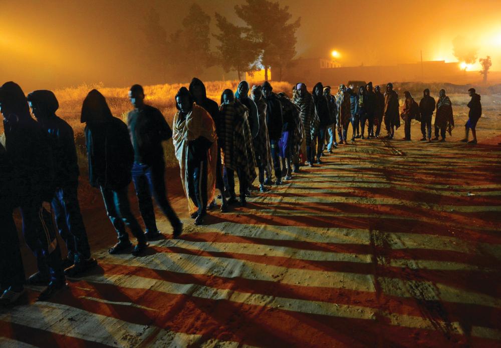 Des demandeurs d'asile faisant la queue pour une distribution de nourriture dans le centre de détention de Dhar el-Jebel/Zintan. Libye. 2019. 