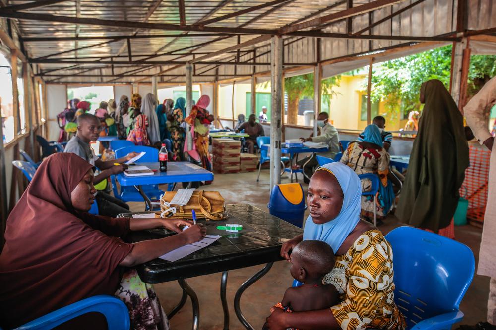 A mother and her child are waiting for a malnutrition screening in the ATFC of Riko, Katsina State, Nigeria, June 2022. 