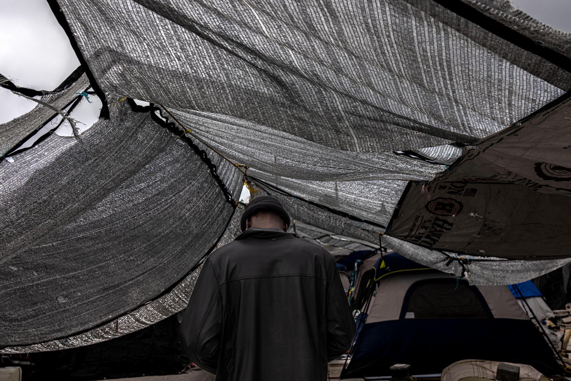A Haitian migrant walks under the shade of mesh tarps in the "Senda de Vida" shelter in Reynosa, Mexico. 