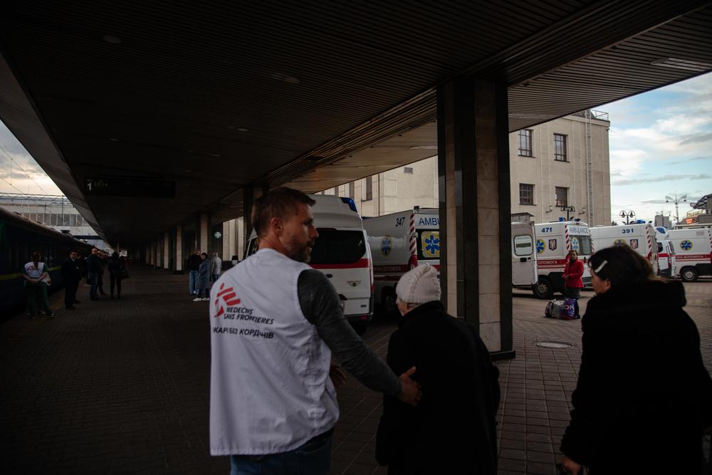 Yaroslav Vodolaga, a doctor on the MSF medical train, brings a patient to a bus that will transport them to a hospital in Kyiv. 