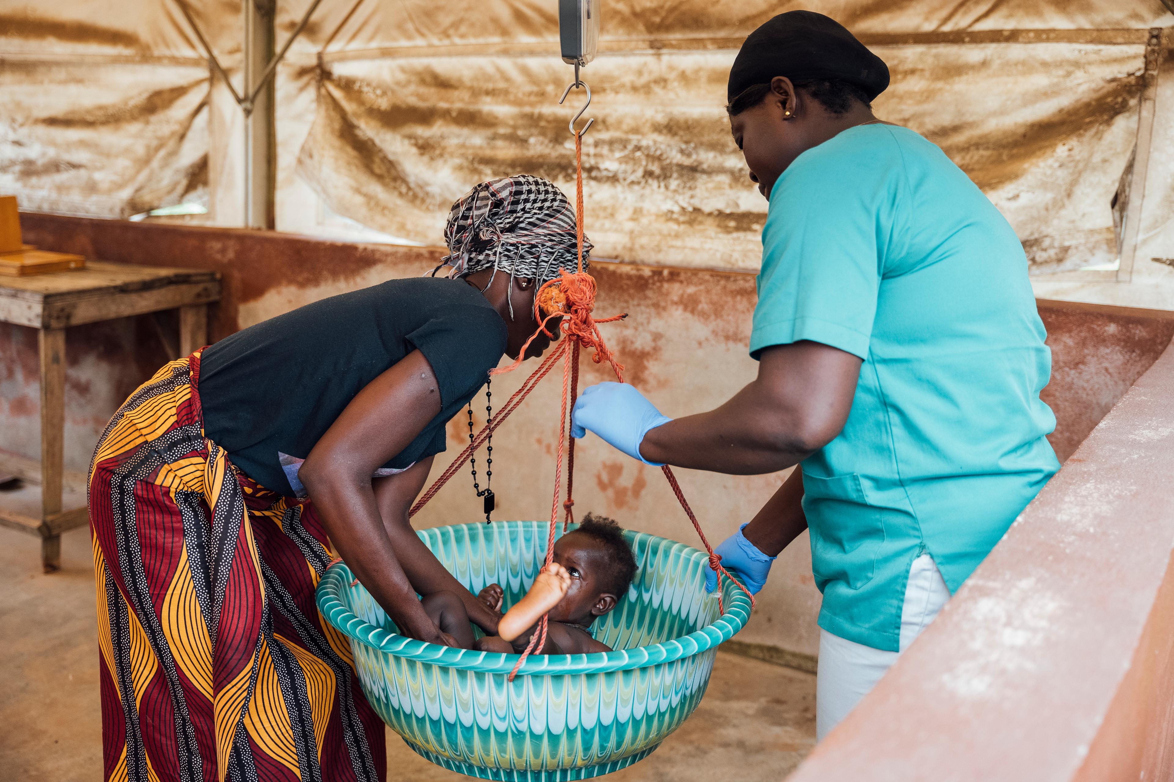 Marie a amené son enfant pour qu&#039;il soit soigné au centre de santé communautaire (CHC) soutenu par MSF à Mile 91, Tonkolili. 