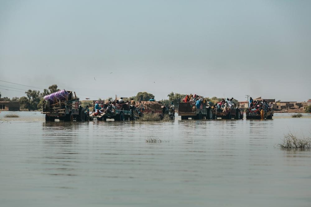 People use tractor carts as transport as roads begin to reappear following the receding flood waters, Dadu district, Sindh. 