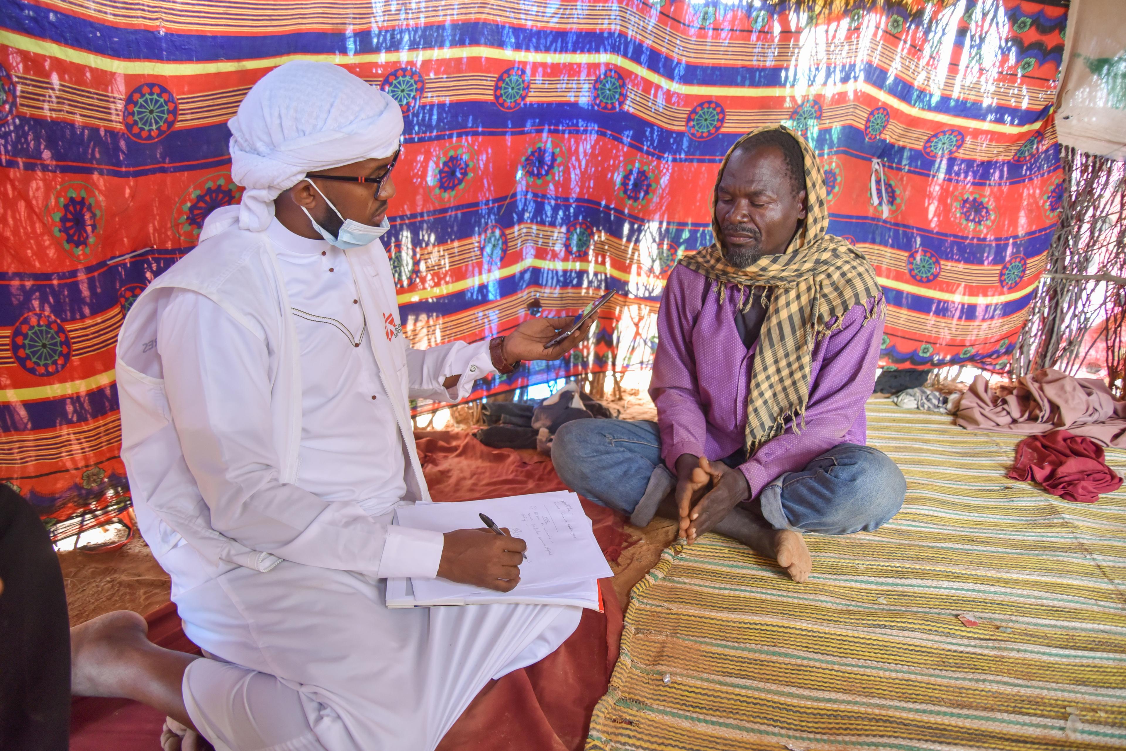 Borow Ali talks to MSF health promotion supervisor Sheriff Abdi during an interview inside their shelter. 