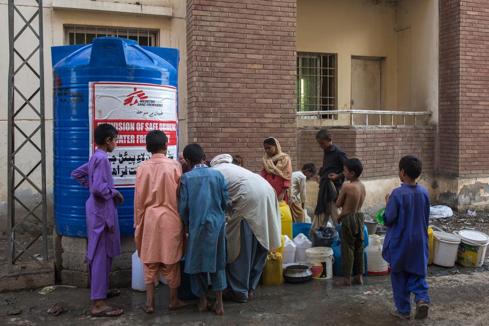 People collect drinking water from the tank installed by MSF in the flood camp of Sukkur labor colony, Sindh province, Pakistan. 