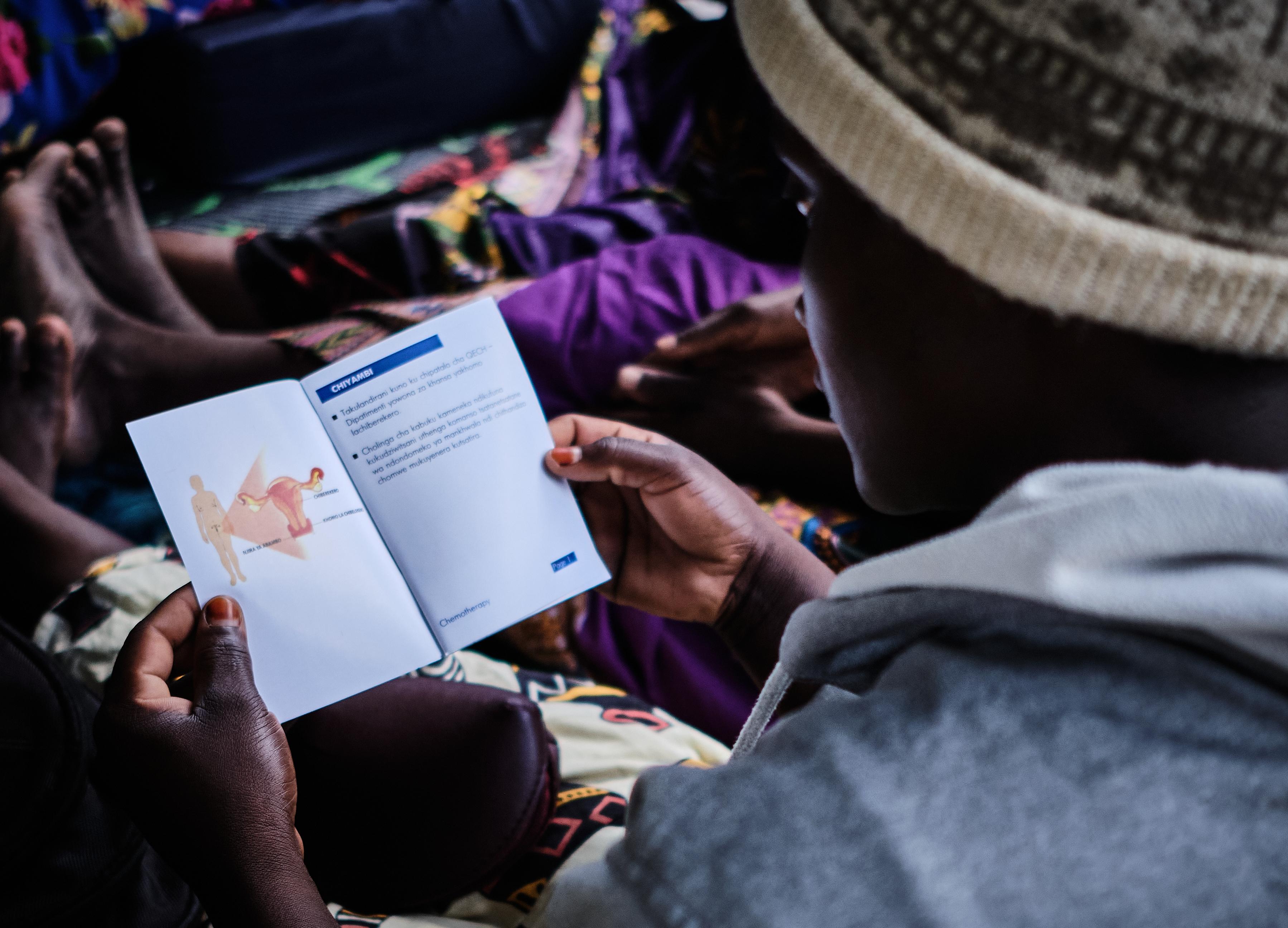 A patient flips through a document prepared by MSF that contains information about the disease and chemotherapy. 