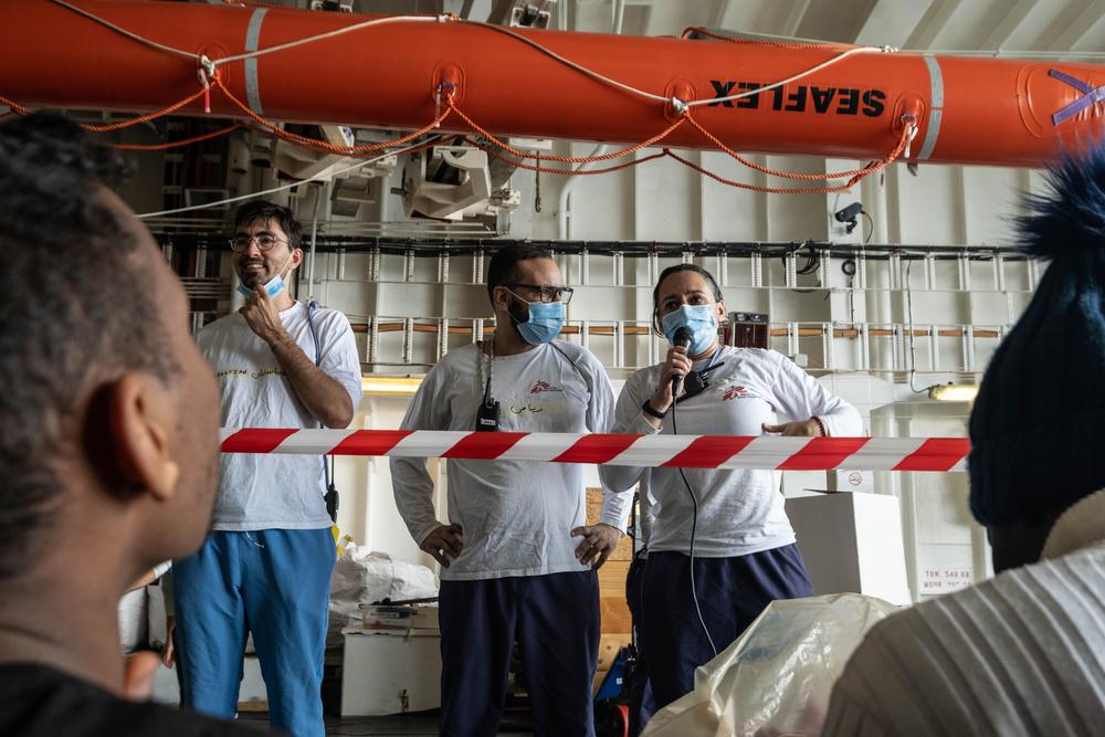 Lucia (à droite), coordinatrice adjointe du projet, accueille les survivants à bord du navire de sauvetage Geo Barents, en compagnie du médiateur culturel Riad (au milieu) et de l&#039;officier de liaison humanitaire Sébastien (à gauche). 