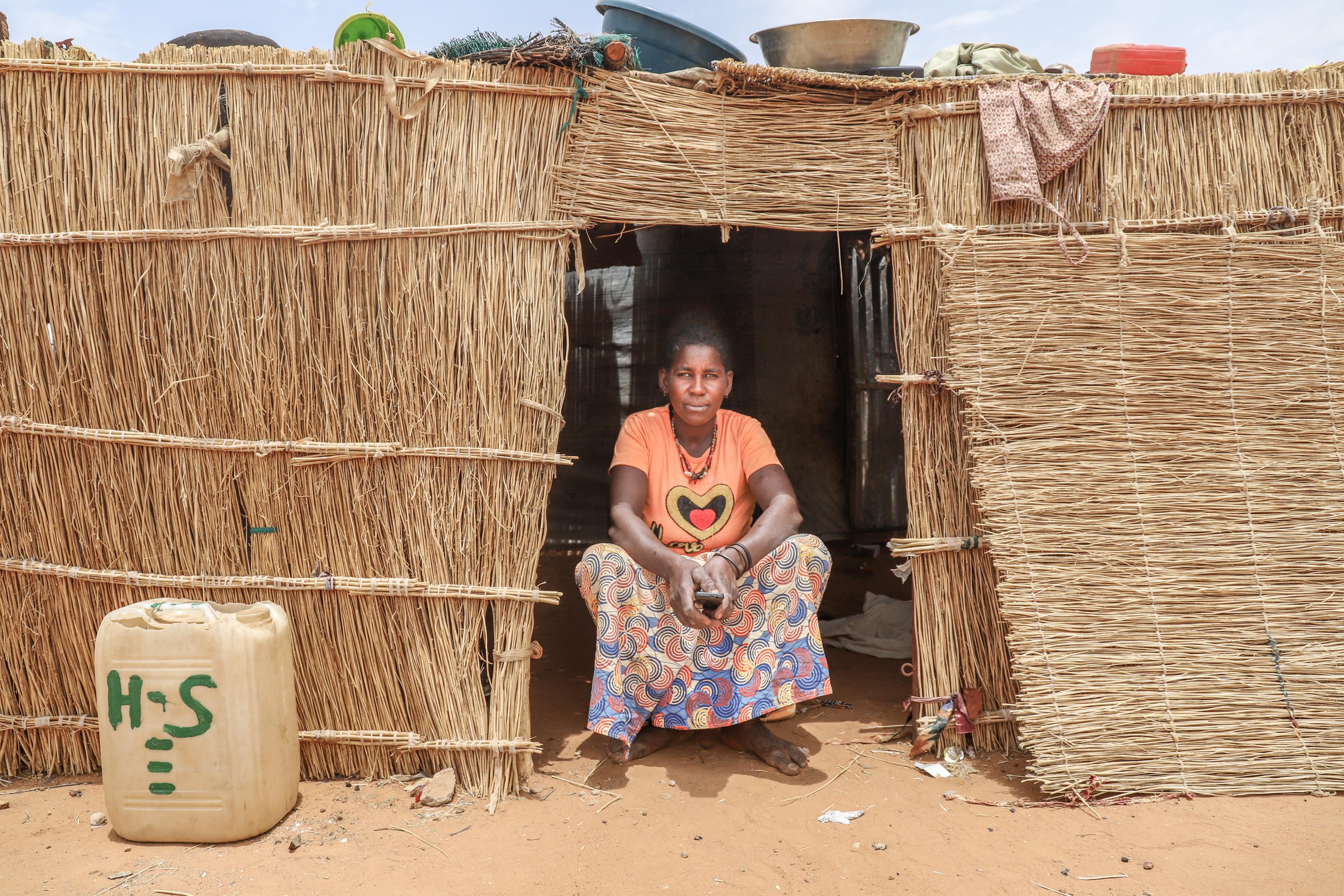Safi 30 ans, mère de 5 enfants, réfugiée du village de Yalanga devant sa hutte à Djibo.