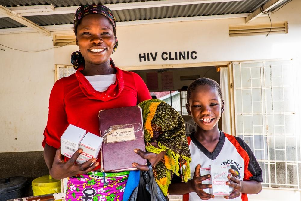 Tsandia and Kristian with their medication and health booklet, happy to be treated, at the HIV ward of Arua Regional Hospital, Uganda. 
