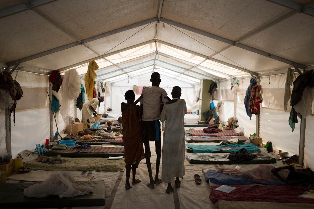 Ruai Puot Malow (56), suffering from kala azar, is assisted by his wife and a relative at an MSF hospital in Lankien. 2015. Karel Prinsloo 