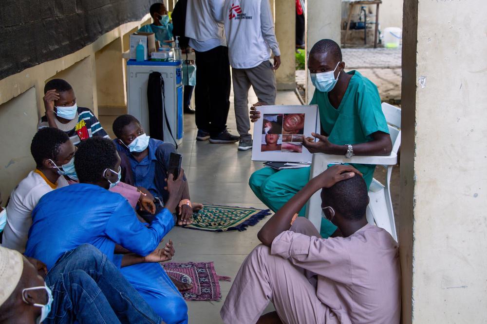 Un promoteur de santé enseigne les symptômes de la diphtérie à un groupe de patients masculins et de soignants à l'hôpital spécialisé Murtala Mohamed, afin qu'ils puissent partager leurs connaissances une fois de retour dans leur communauté. 