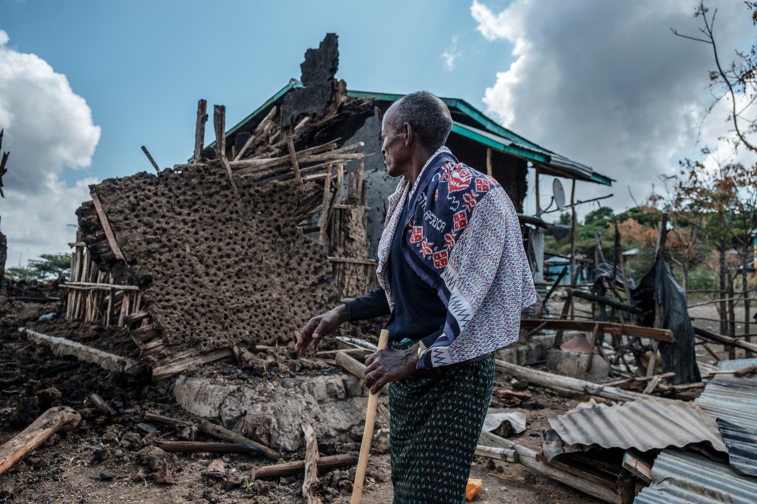 A man stands in front of his destroyed house in the village of Bisober, Ethiopia, on December 9, 2020. 