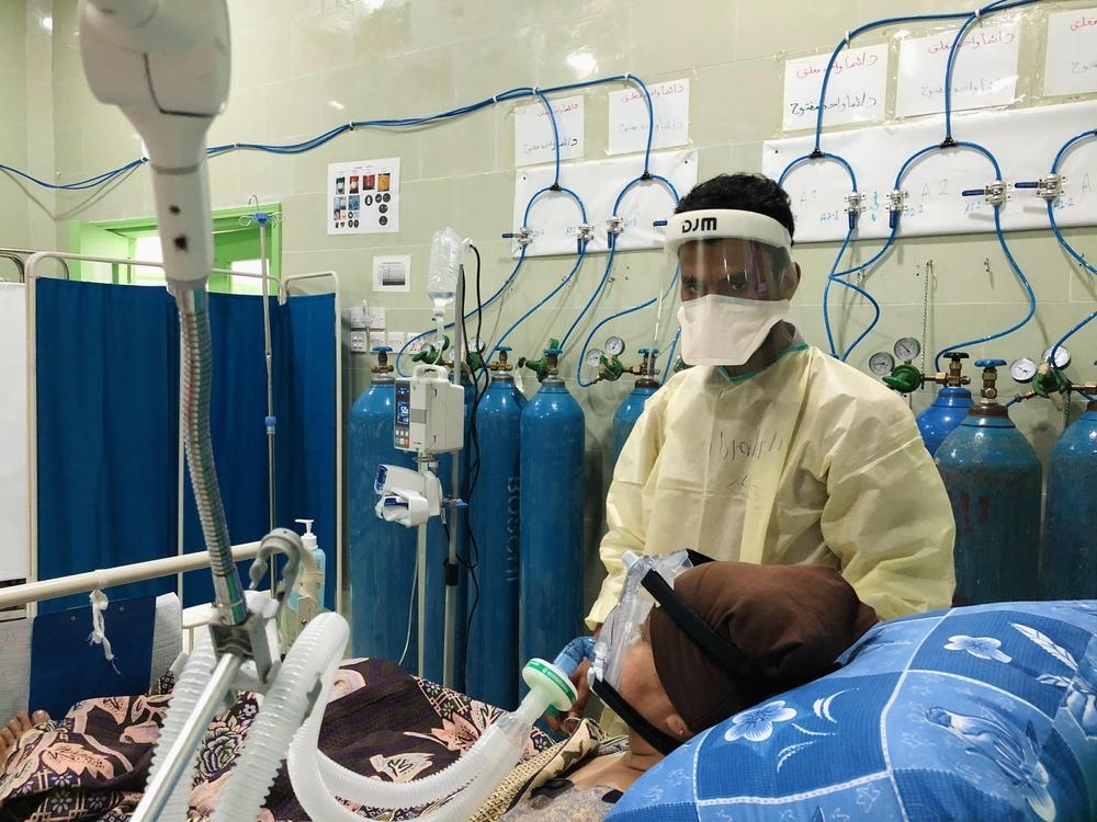 Un membre du personnel médical s'occupe d'un patient dans l'unité de soins intensifs de l'hôpital Al Gamhouria à Aden, mars 2021. 