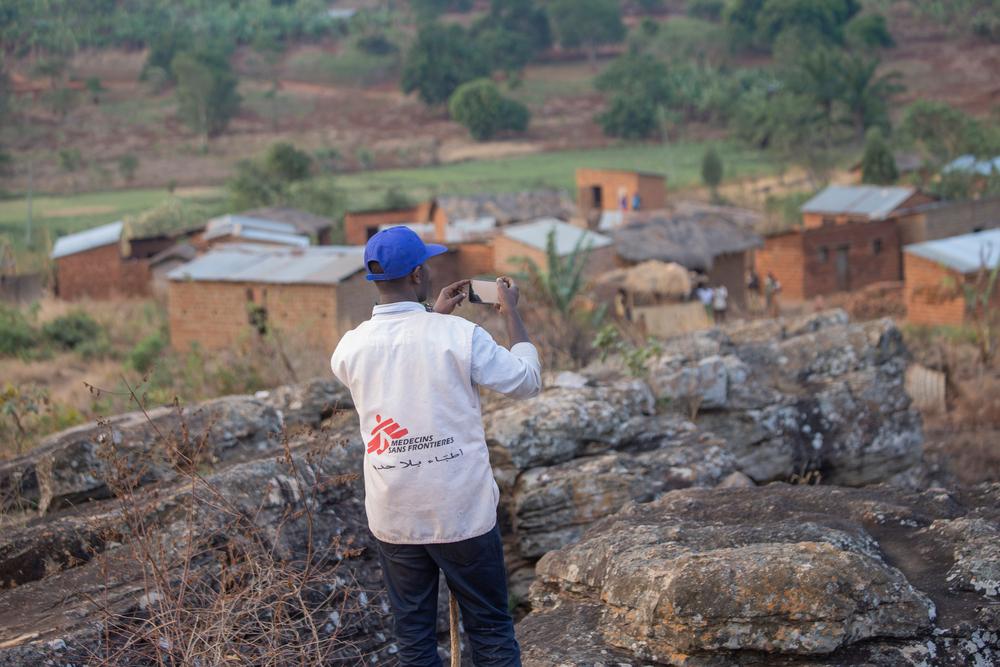 Ramadhan Nzobonimpa, responsable de la promotion de la santé chez MSF, prend des photos sur la colline de Ruyaga où des équipes ont été envoyées aujourd&#039;hui pour traiter les maisons contre les moustiques.