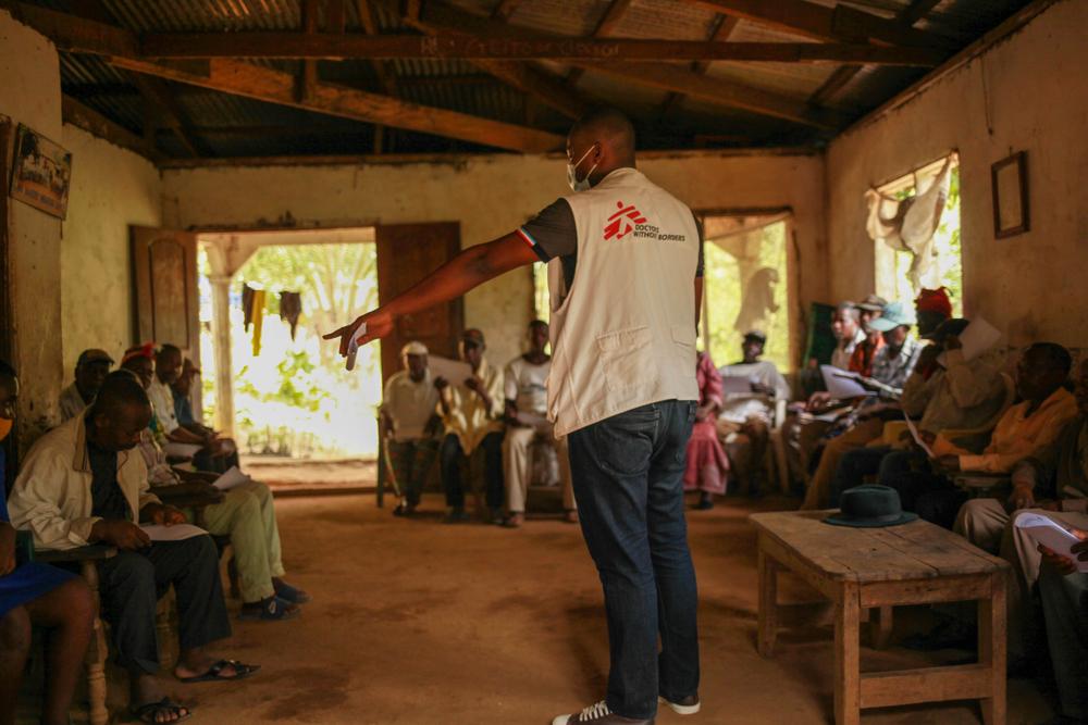 Ambebila Jude, an MSF nurse, talks to community leaders in the village of Mbakwa Supe. 