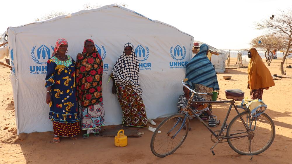 Women stand next to a tent at a site for internally displaced people in Gorom Gorom, in the Sahel region of Burkina Faso. 