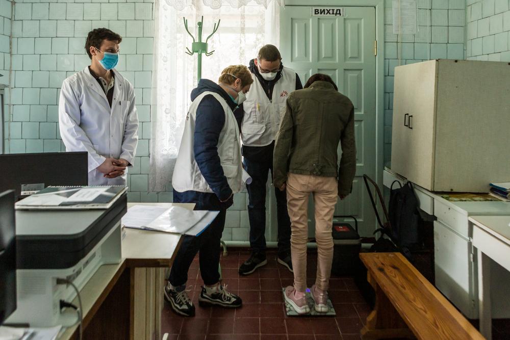 Anna Antypenko, infirmière MSF, et Oleksandr Nazin, travailleur social MSF (au milieu, vêtu de bleu), vérifient le poids d&#039;un patient atteint de TB dans le district de Korostyshiv, région de Zhytomyr, Ukraine. 